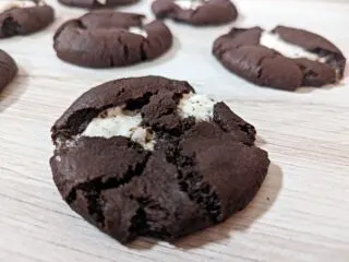 Closeup of chocolate marshmallow cookies on a wooden board.