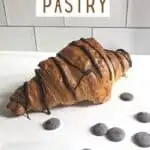 Chocolate drizzled croissant with text chocolate pastry.