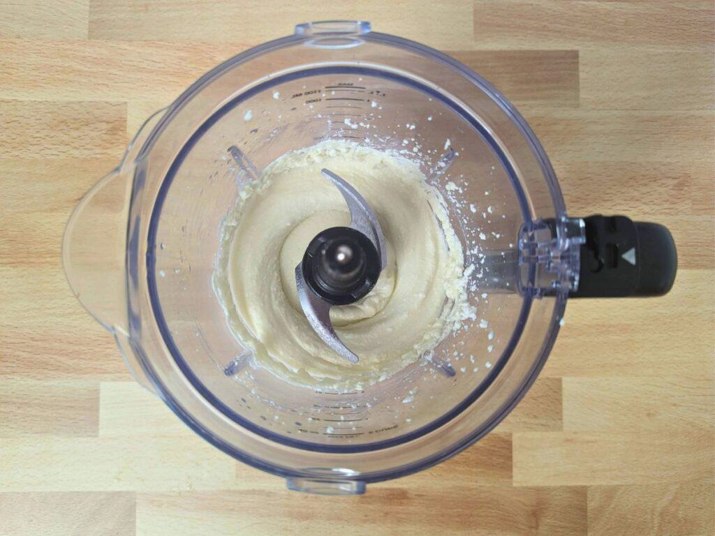 Image shows an Overhead shot of whipped ricotta in a blender.