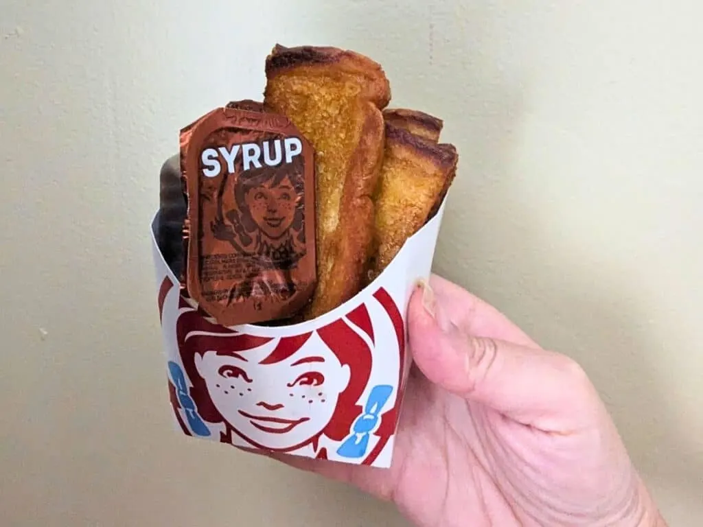 Image shows Wendys French Toast Sticks against a solid background.