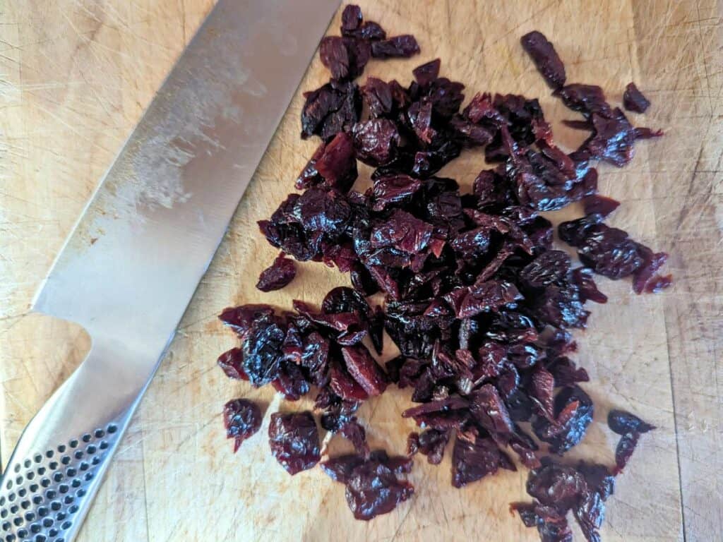 Image shows Overhead shot of chopped dried cherries.