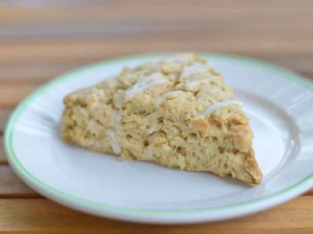 Image shows a Chai Scone on a white plate sitting on a wooden table.