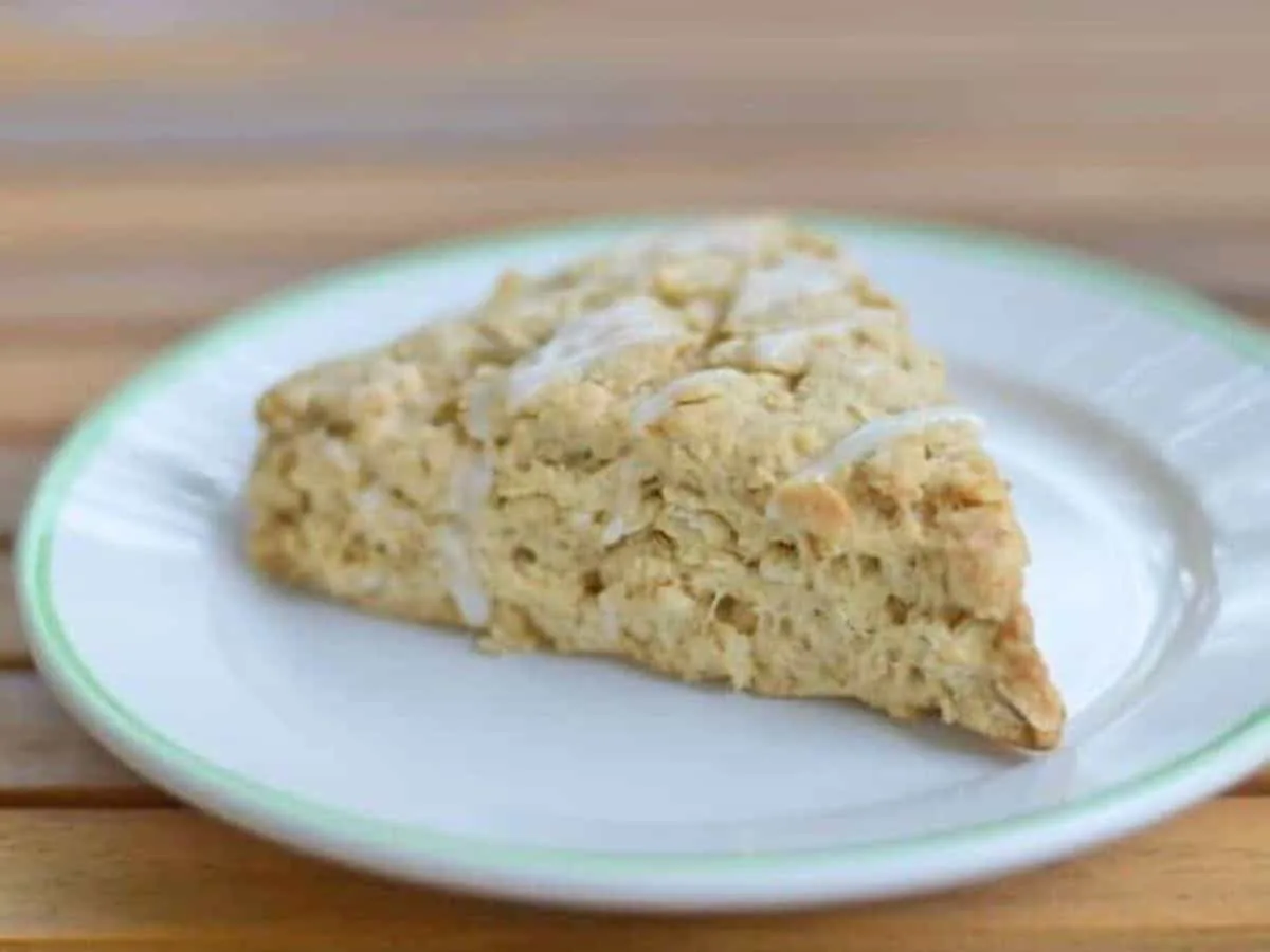 Image shows a Chai Scone on a white plate sitting on a wooden table.