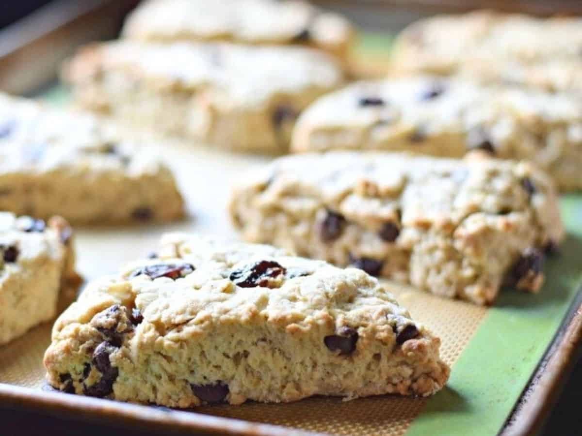 Image shows Cherry Chip Scones on a baking sheet with the sun coming in from the back.