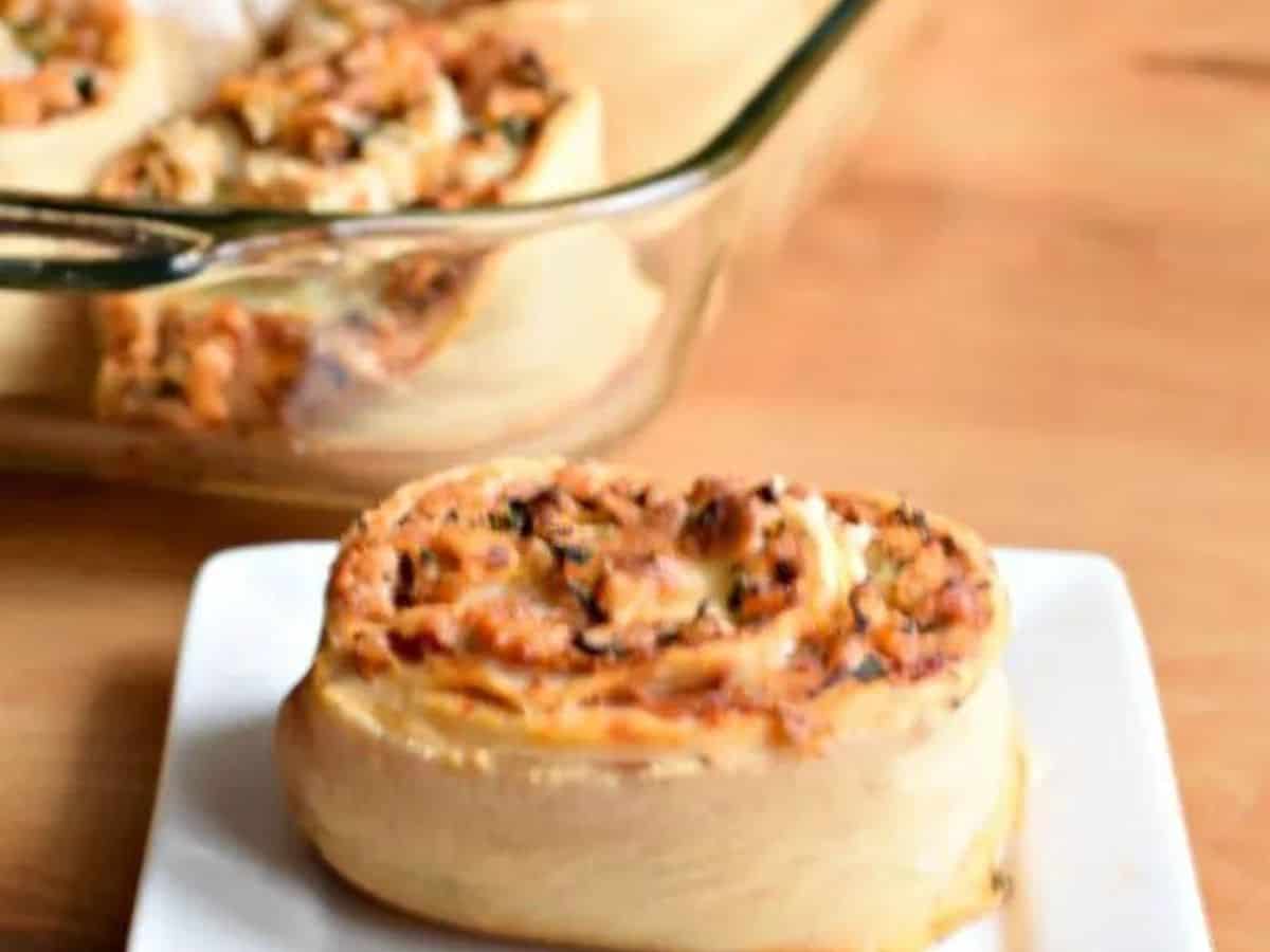 Image shows a Pizza roll on a white plate in front of a pyrex with the rest of the batch in it.