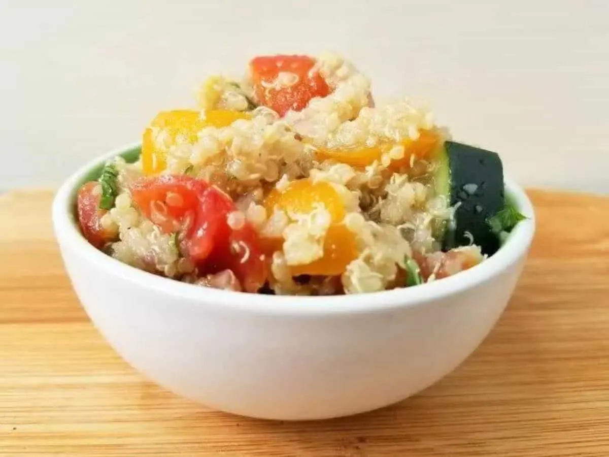 Image shows shows a closeup of Tomato Quinoa Salad in a small white bowl.