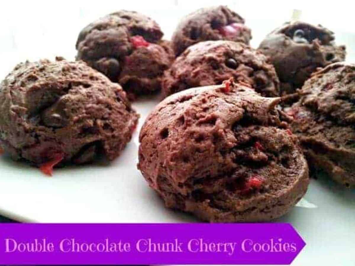 Image shows double Chocolate chunk cherry cookies on a white plate.