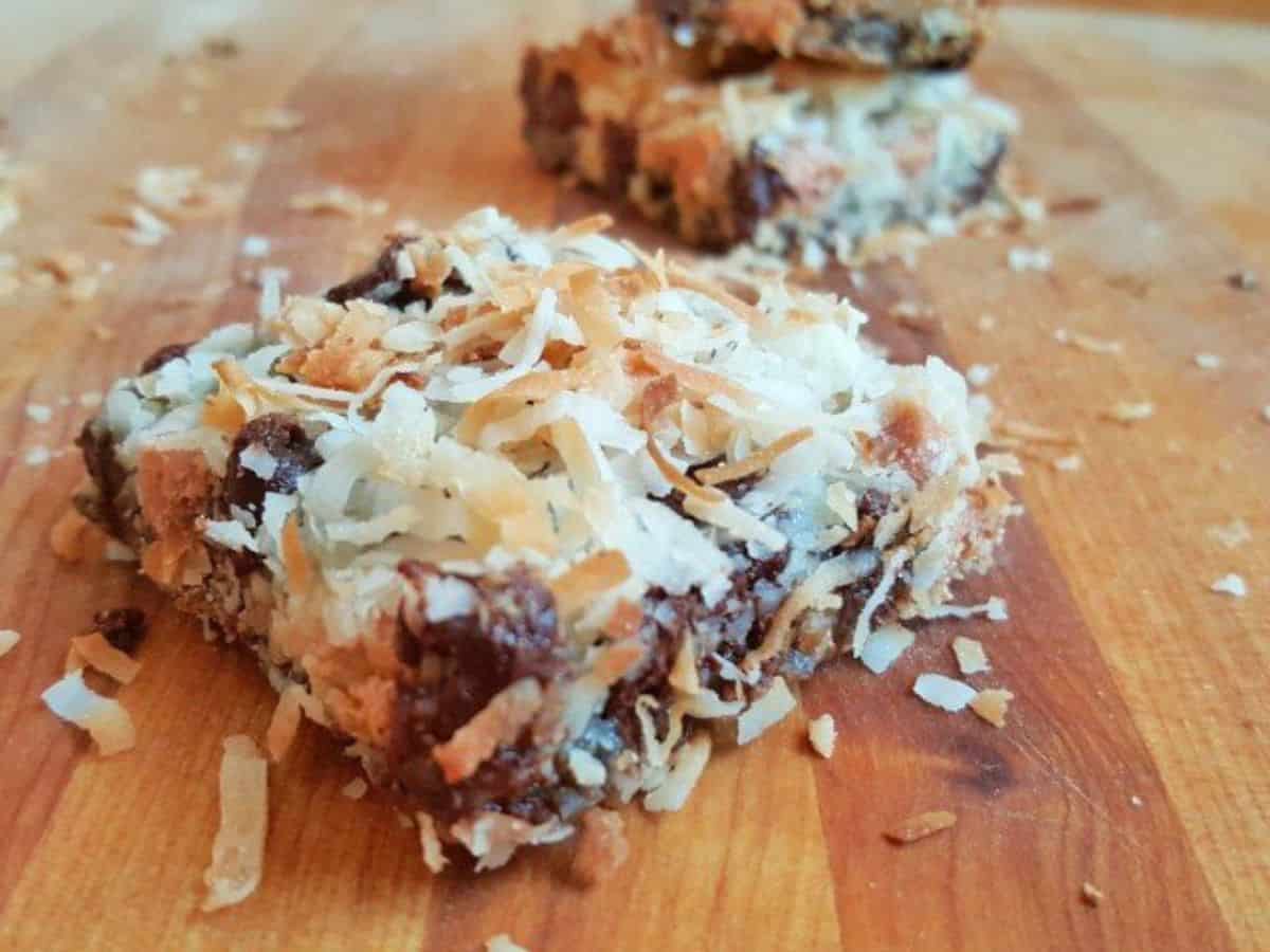 Image shows 7 layer bars on a wooden cutting board.