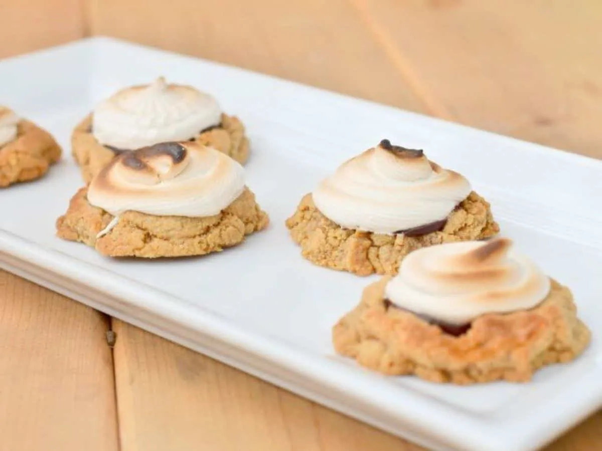 Image shows Toasted smores cookies on a white tray.