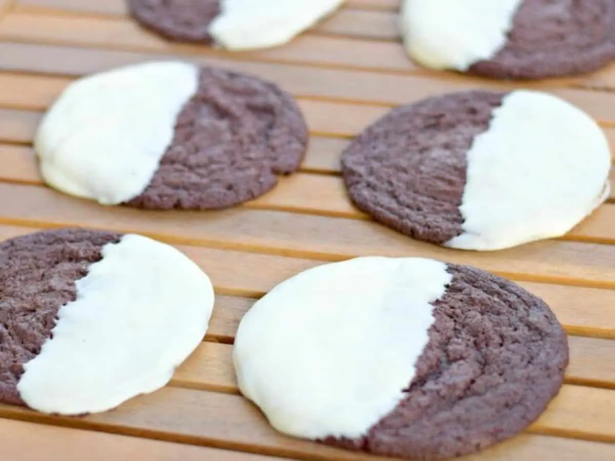 Image shows four Copycat Mrs. Field's Chocolate Dipped Cookies on a wooden table.