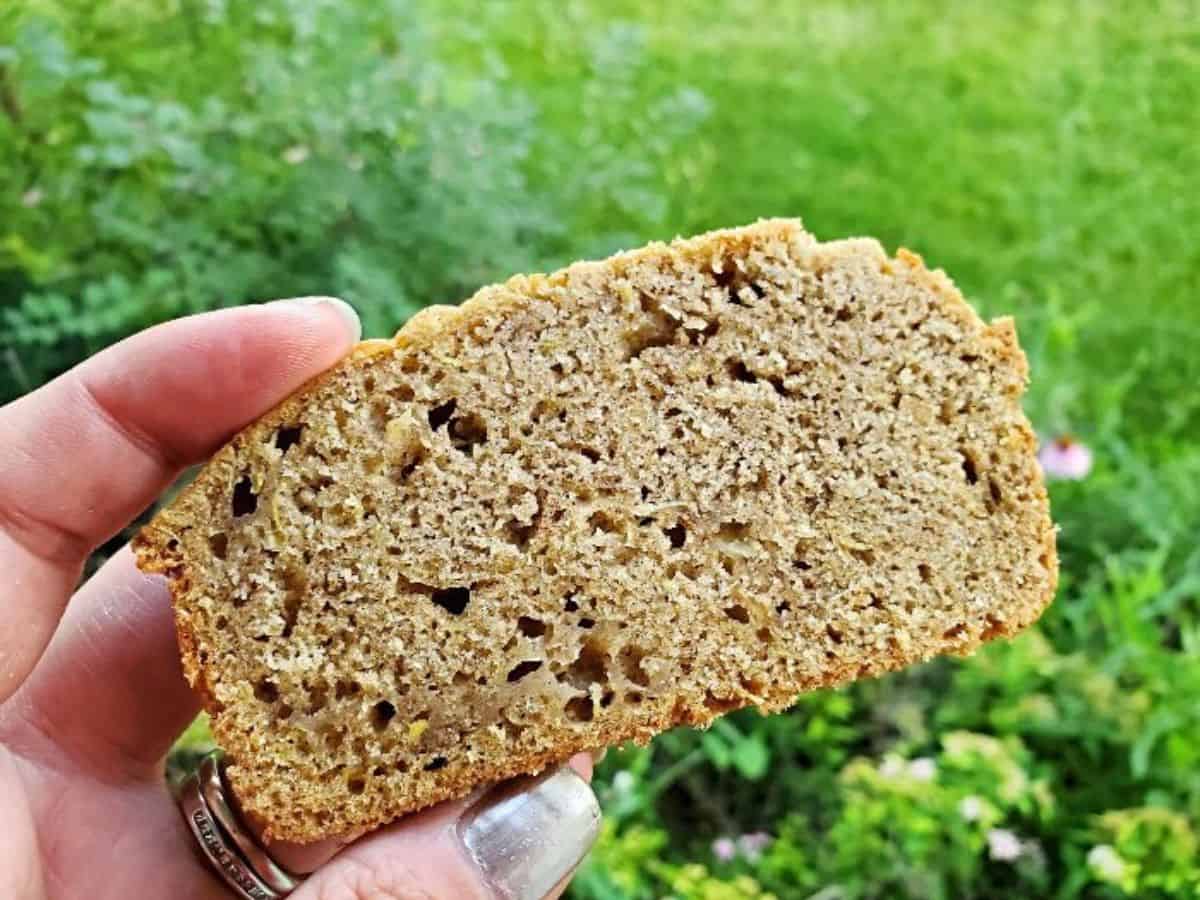 Zucchini bread loaf with slices on a cutting board.