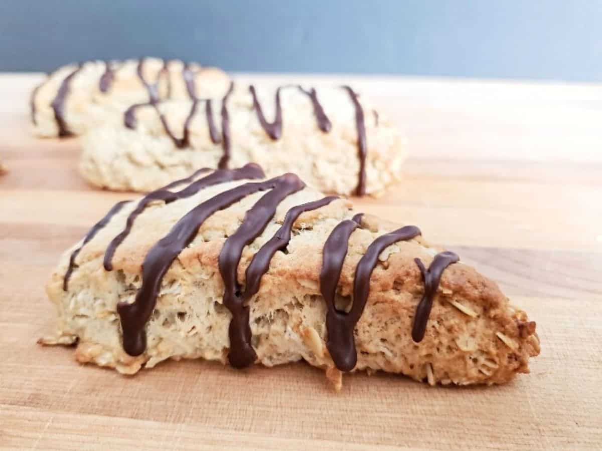 Image shows Chocolate drizzled mocha scones on a cutting board.