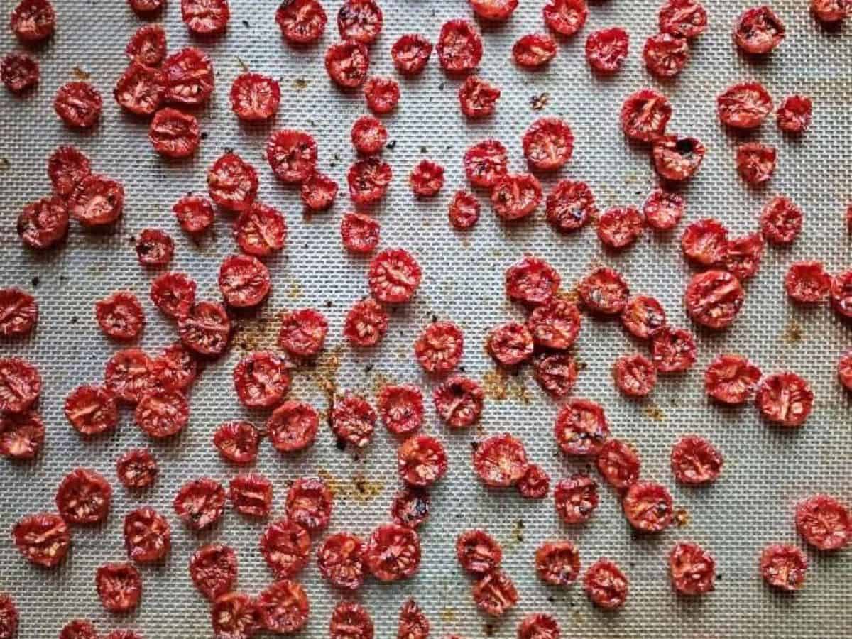 Image shows an overhead shot of Slow Roasted Italian Tomatoes on a silpat baking sheet.