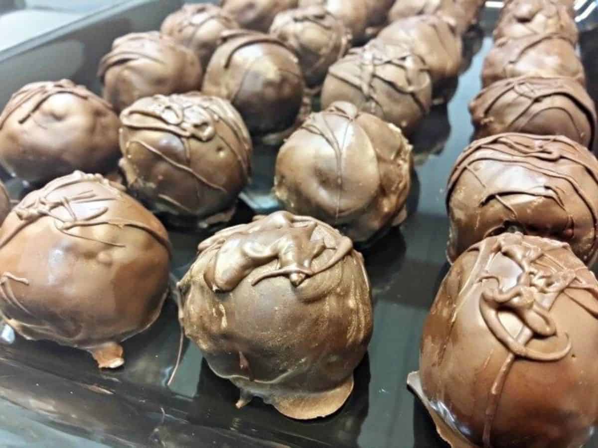 Image shows Chocolate chip cookie dough truffles on a white plate.