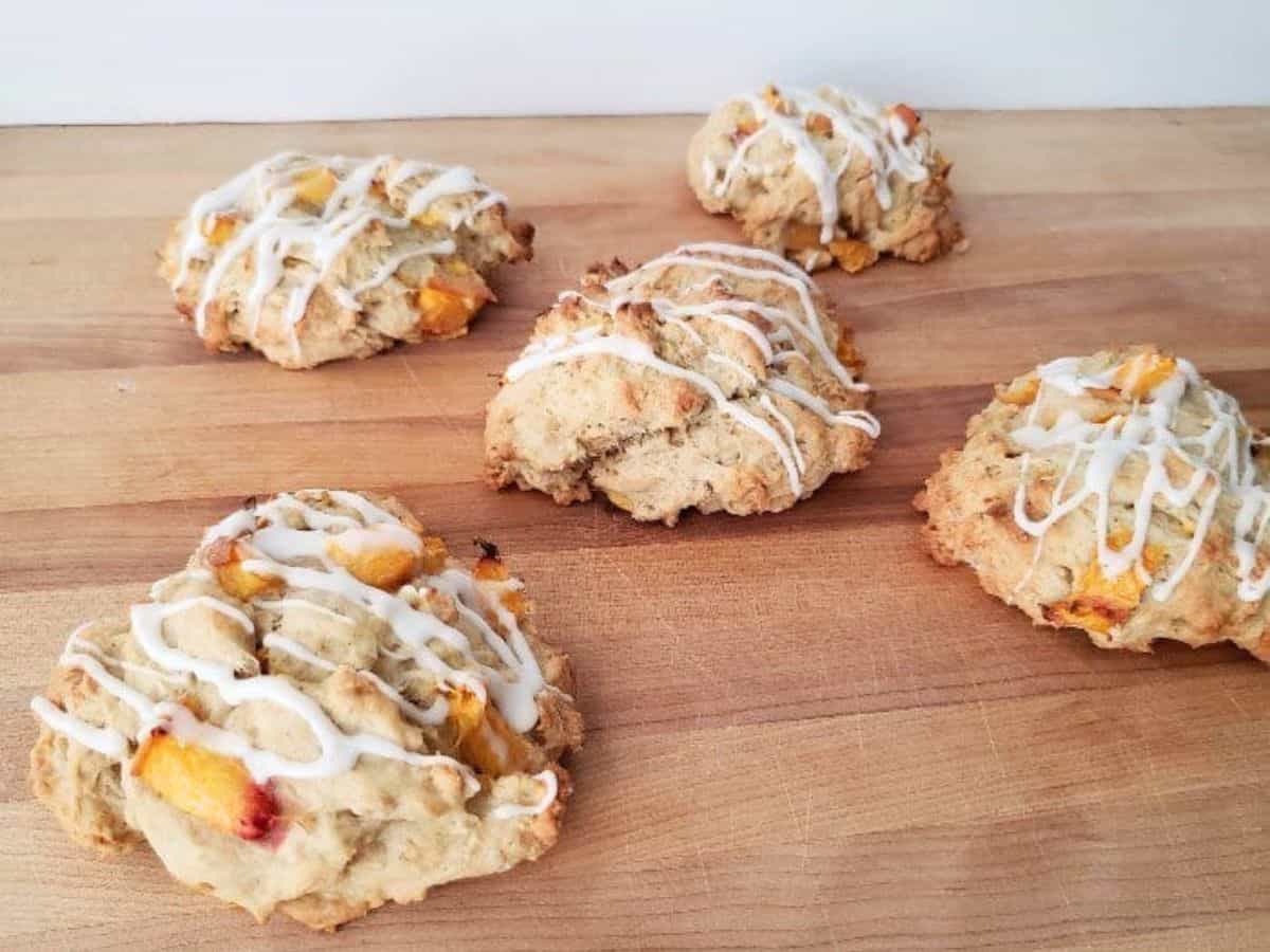 Image shows  Peach scones with icing on a cutting board.