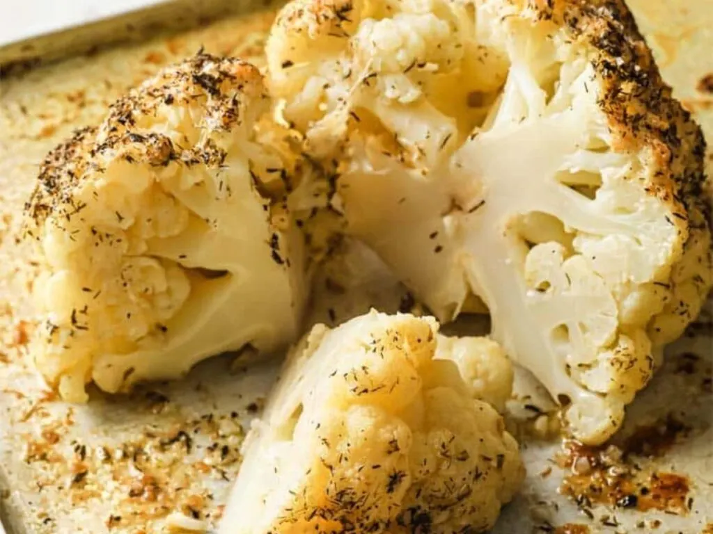 Image shows irresistible buttery whole roasted cauliflower.