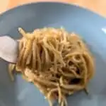 Image shows bite of cooked lemon butter pasta.