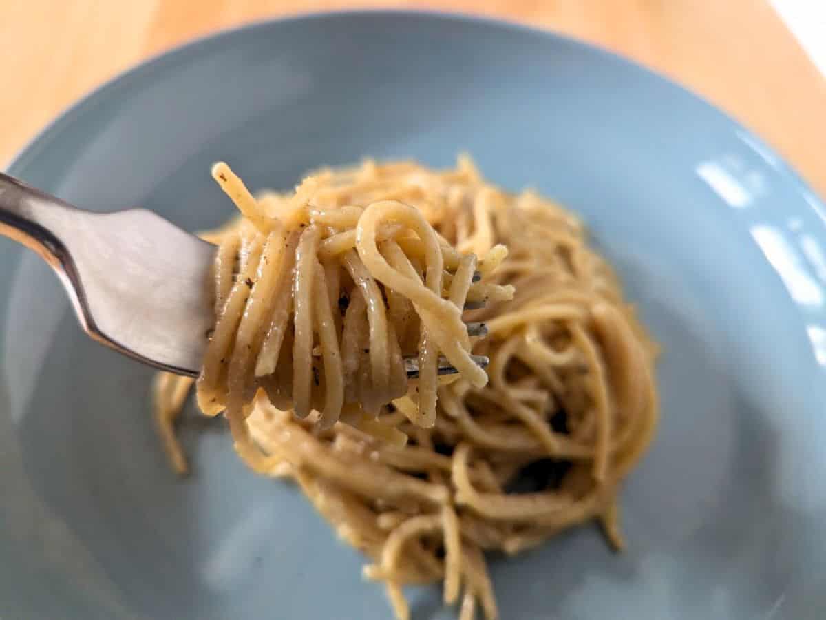 Image shows bite of cooked lemon butter pasta.