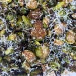 Image shows overhead of roasted brussels sprouts with pine nuts.