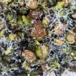 Image shows overhead of roasted brussels sprouts with pine nuts.