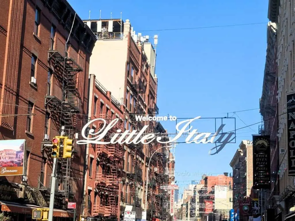 Image shows a street with a Welcome to Little Italy sign strung across it.